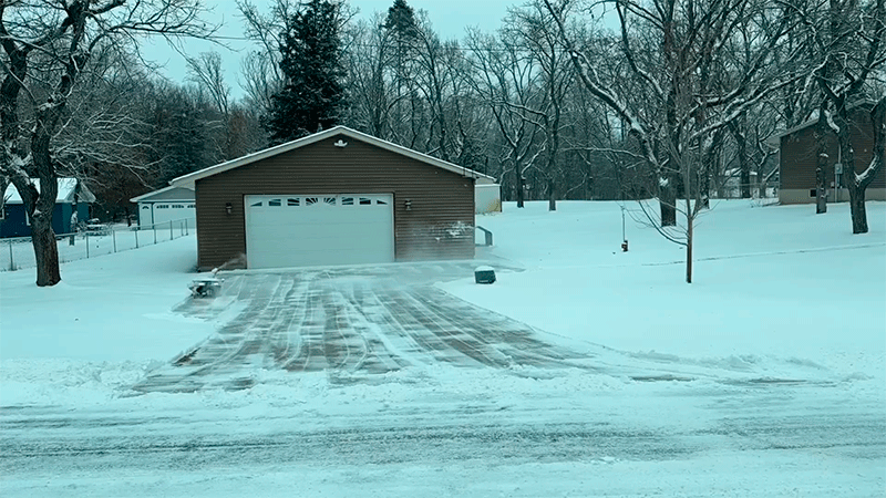 Робот-снегоуборщик Yarbo Snow Blower очищает длинную подъездную дорожку к гаражу после снегопада